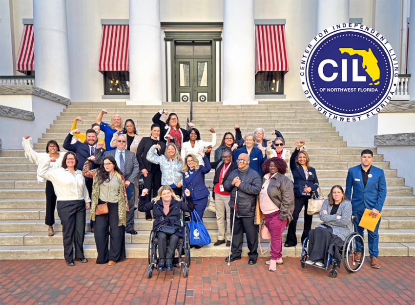 Group photo for CILNWF on and in front of a stair case. Everyone is holding out an arm in a gesture like showing off muscles