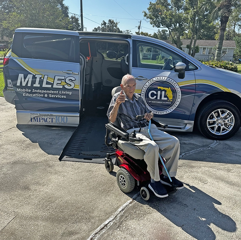 Cecil Sakalarois giving a thumbs up in the Power Chair he received form CIL’s durable medical equipment program that was delivered utilizing MILES vehicle provided by the IMPACT100 grant. 