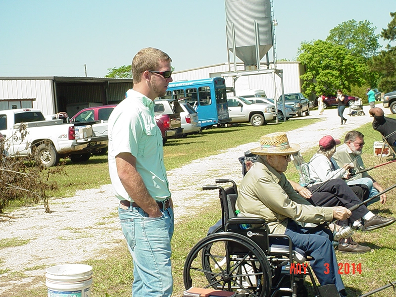 participants at Penwheels Fishing Rodeo in a line holding fishing rods